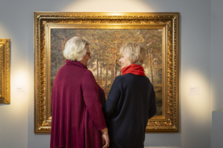 Kaksi ikäihmistä katsoo taulua museossa.