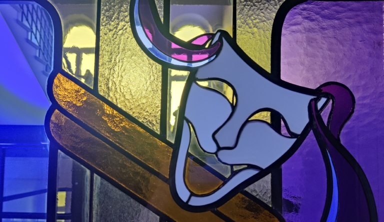 Teatterin lasiovi, jossa teatterimaskit.