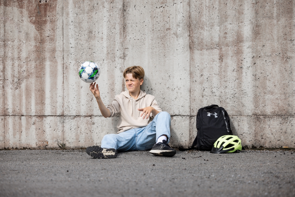 I bilden ungdom, pojke, fotboll, ryggsäck, betongvägg, cykelhjälm
