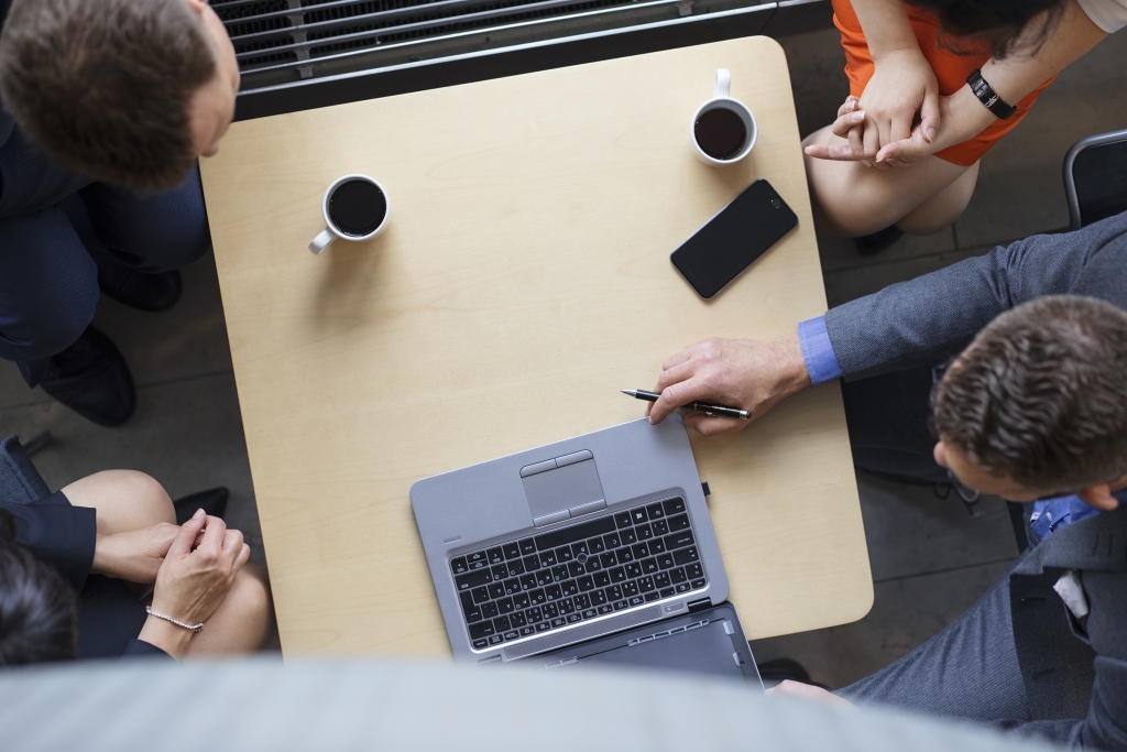 People sitting around a table. Picture taken from a birdview.