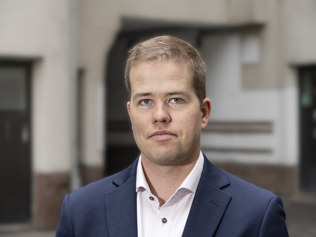 Henkilö pukeutuneena tummansiniseen pukuun.