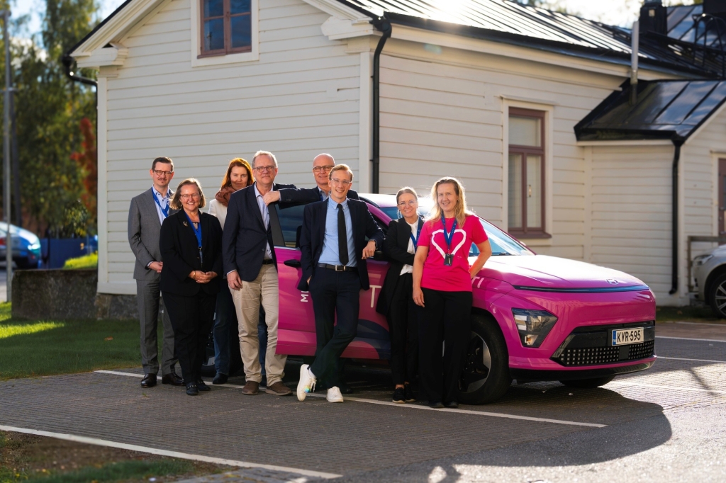 Stadsdirektören och beslutsfattarna poserar framför Mini-Lifti-elbilen.