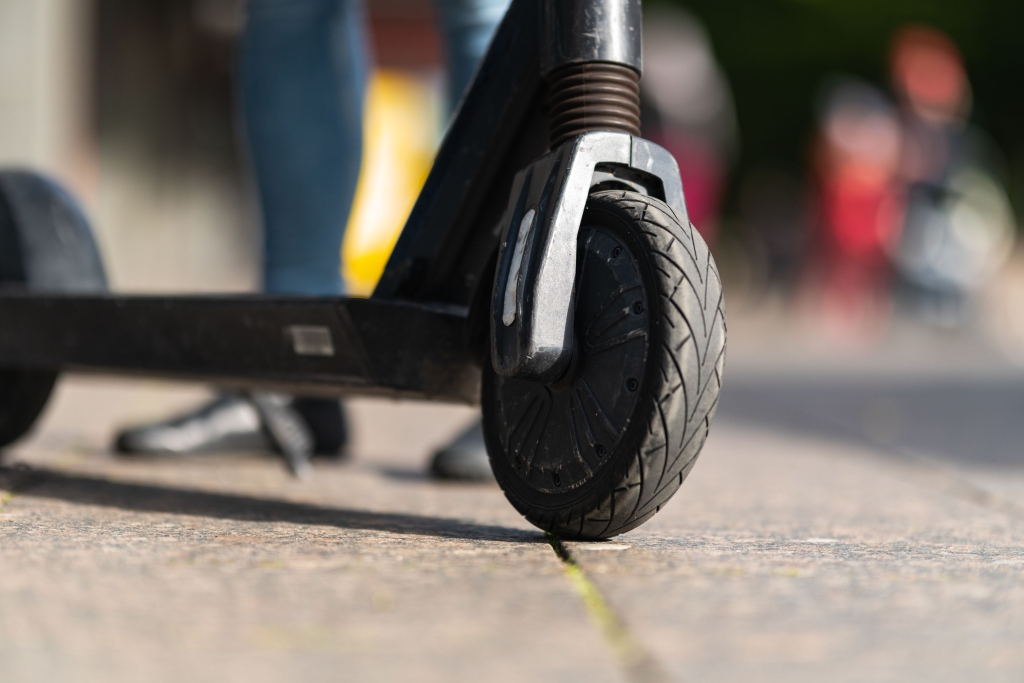 Close-up of the front wheel of an electric scooter on the street.