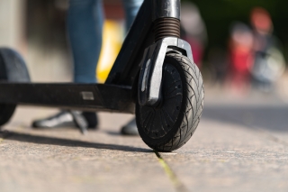 Close-up of the front wheel of an electric scooter on the street.