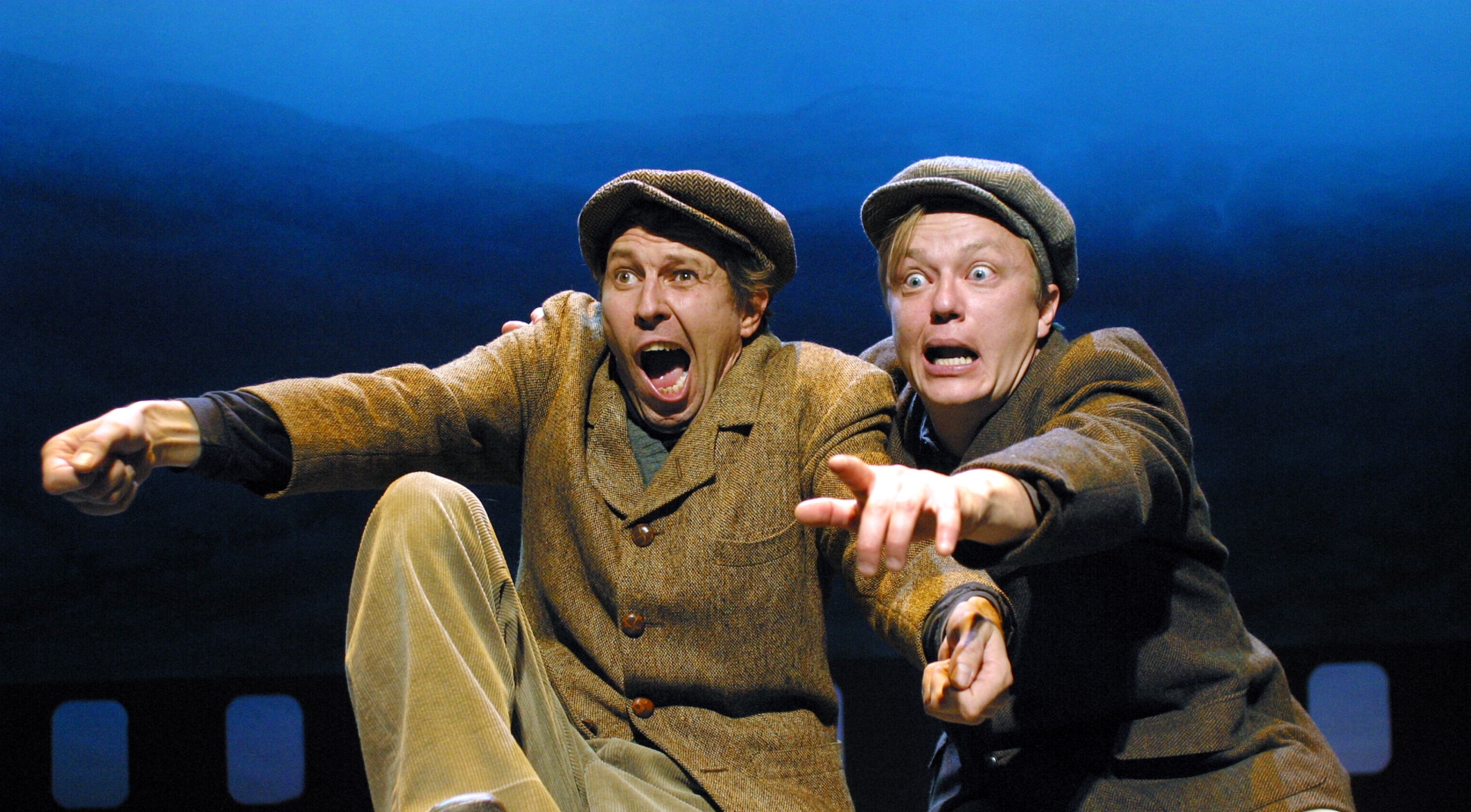 Kaksi henkilöä suut auki, toinen osoittaa sormellaan eteenpäin.