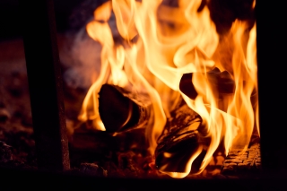 Nuotio, jossa puut palavat ja oranssit liekit nousevat voimakkaina ylöspäin.