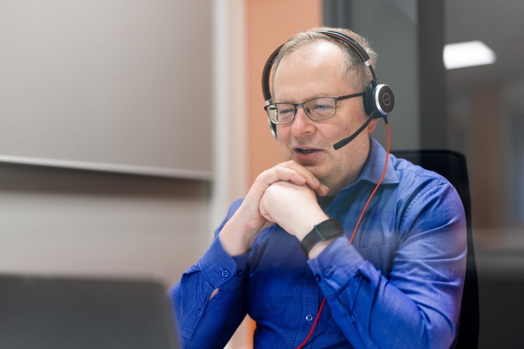 En man i glasögon och med hörlurar på huvudet.