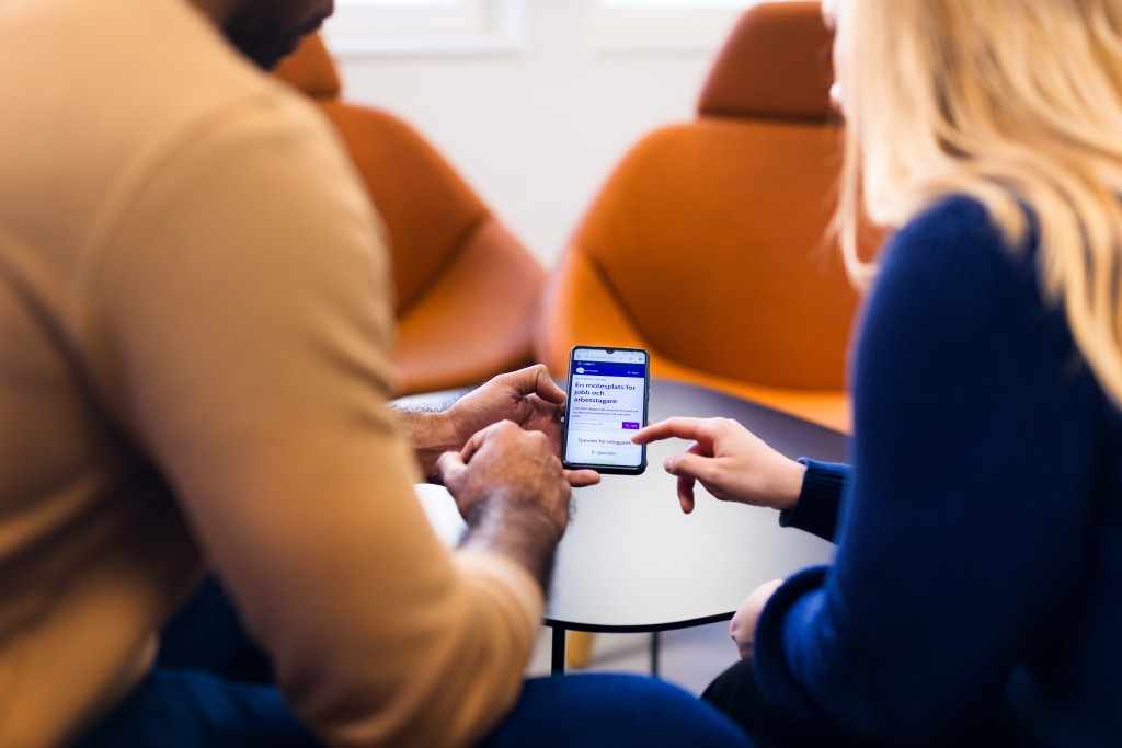 Kaksi ihmistä katsoo puhelimen näyttöä.