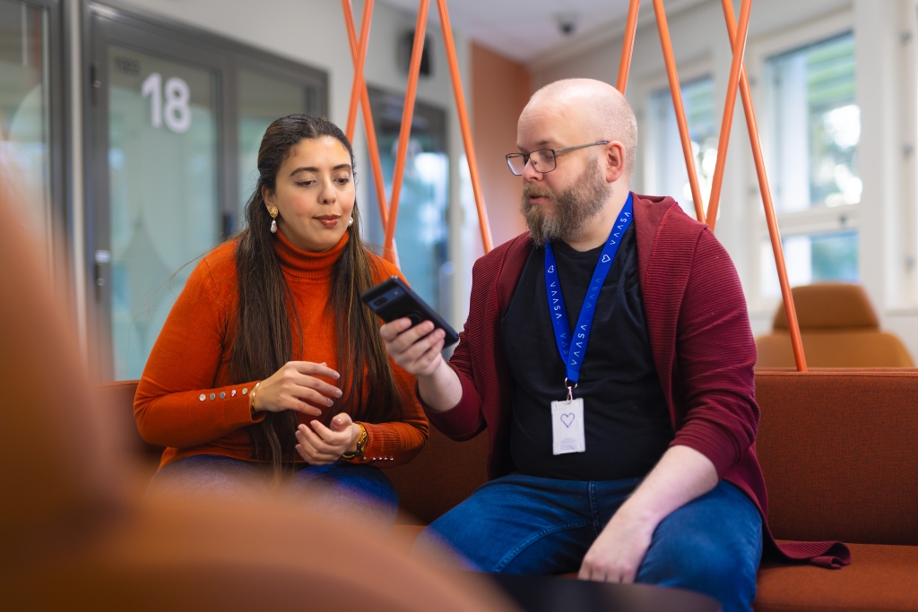 Two people are watching a phone.
