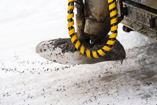 Hiekoituslaite hiekoittaa lumista katua.