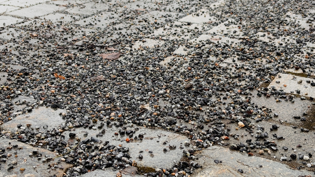 Kivipäällysteinen katu, jossa on paljon pientä soraa.
