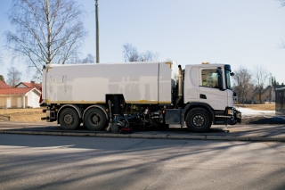 Katua siivoava kuorma-auto pysäköitynä jalkakäytävällä.