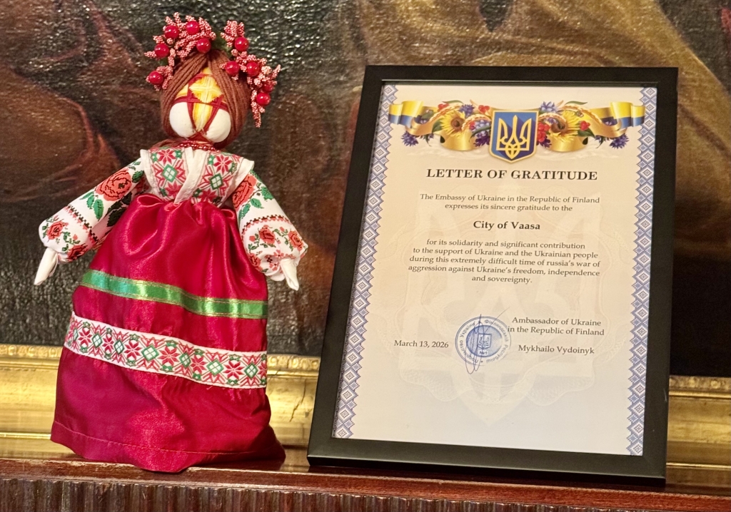 A traditional Ukrainian protective doll and a framed Letter of Gratitude