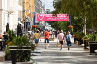 Kävelykatu kesäisellä Hovioikeudenpuistikolla, kukkaistutuksia ja ihmisiä liikkeellä.