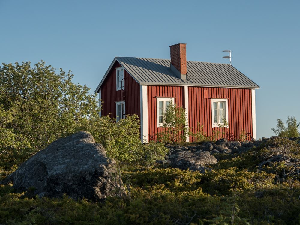 Valassaaretn biologinen asema sijaitsee Äbbskärilla. Punainen puutalo kivikkoisella luodolla.