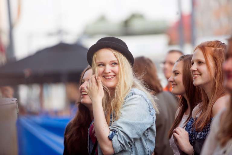 Young people listen to open air concert.
