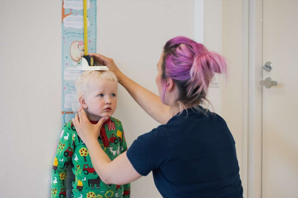 Sjuksköterskan mäter barnets längd