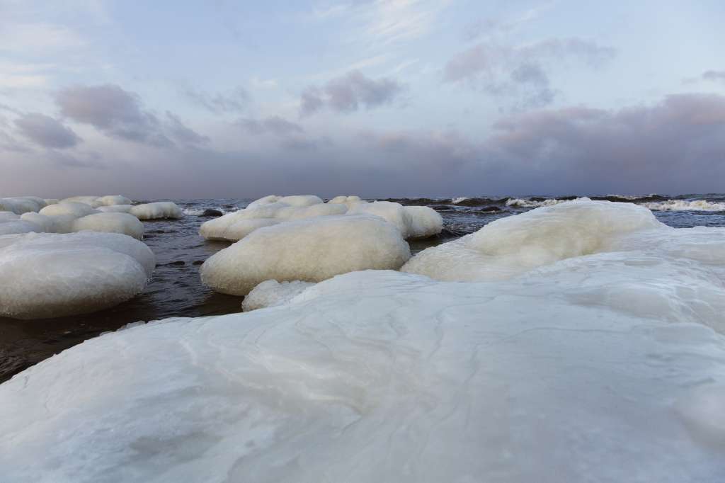 Jääpeitteiset kivet meressä talvella Merenkurkun saaristossa.