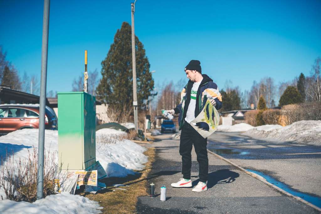 Mies maalaamassa sähkökaappia