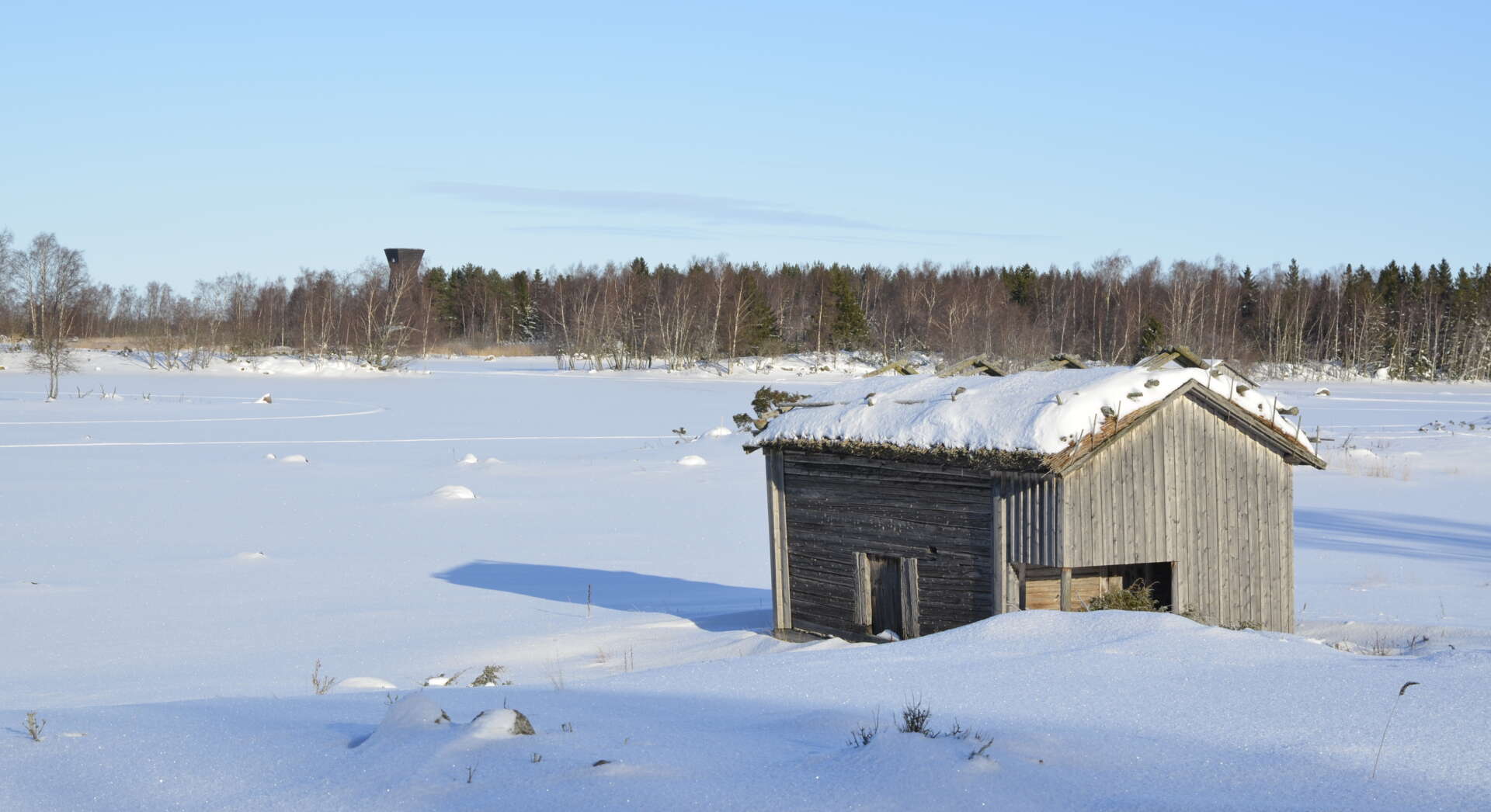 Vinterlandskap med lada och snö