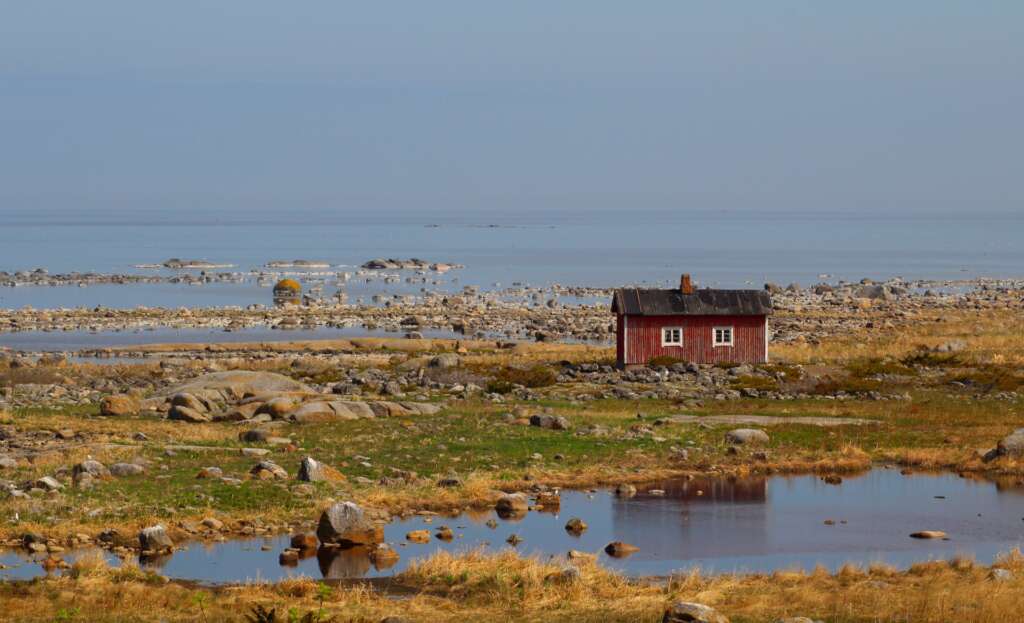 Red boathouse in the middle of rocky outer archipelago island.