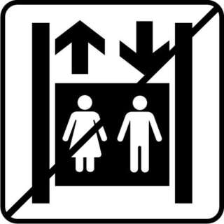 Det finns ingen hiss. Bilden visar en kvinna och en man sida vid sida i en rektangulär hisskorg. De långa lodräta sidorna föreställer hisschaktet, ovanför hisskorgen finns en pil uppåt och nedanför en pil nedåt. Det finns en sned svart linje ovanpå bilden.