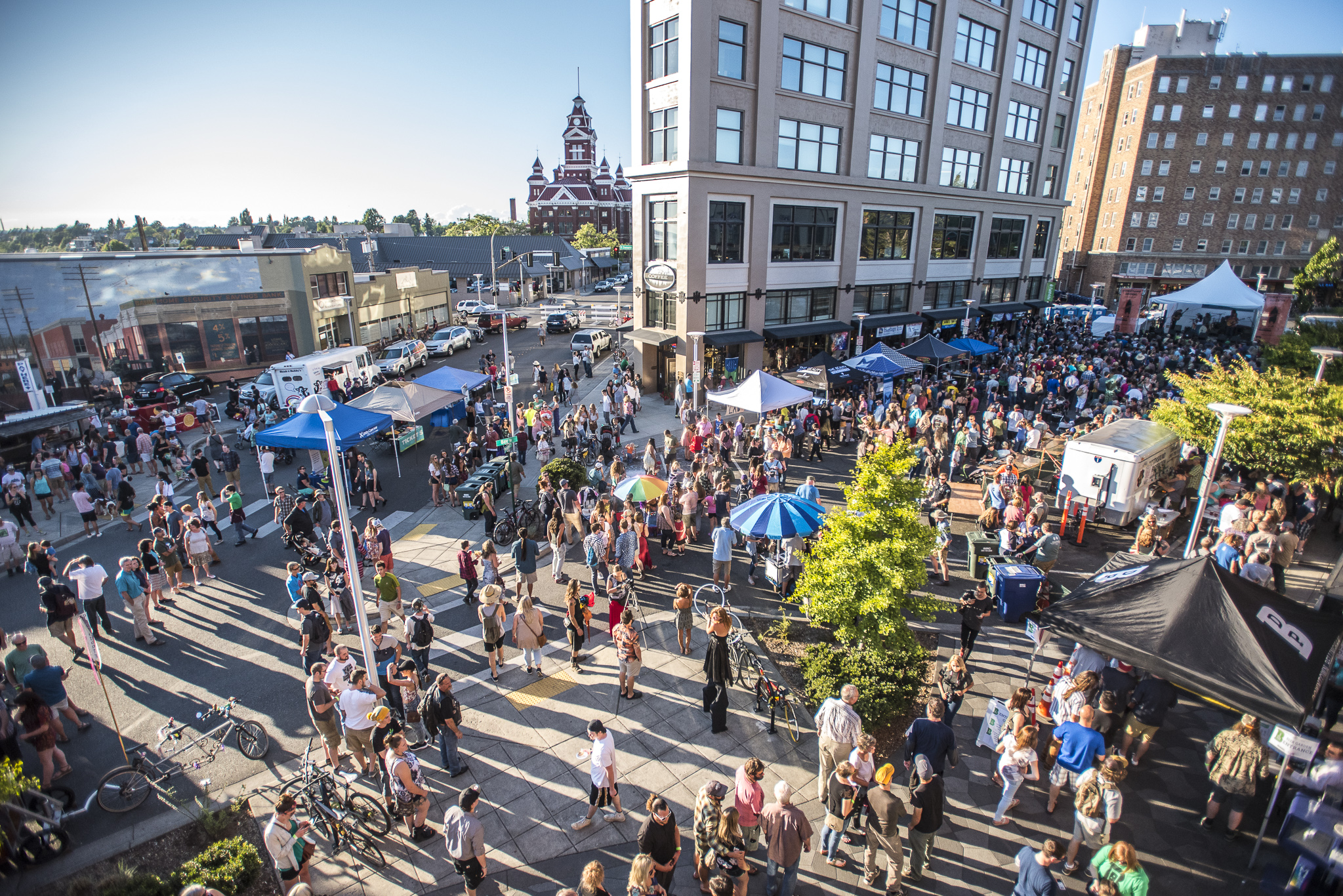 A lively city centre with people visiting pavilions.