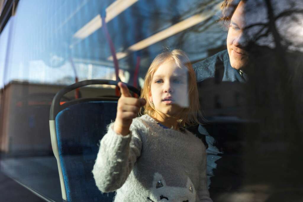 Vanhempi ja lapsi linja-autossa