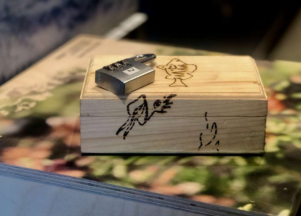 Small wooden box, a padlock on top of it.