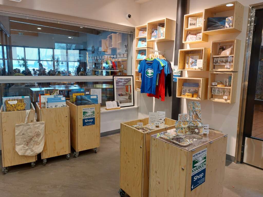 En liten butik i besökscentret Världsarvsporten med vitriner av plywood, T-shirts och andra souvenirer.